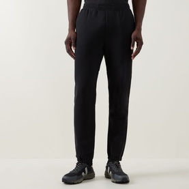 Model wearing Lululemon black sweatpants with tapered leg and elasticated cuffs, styled with dark lace-up trainers.