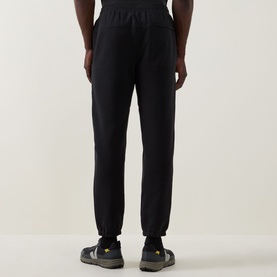 Model wearing Lululemon black sweatpants, rear view, styled with grey and yellow sole trainers