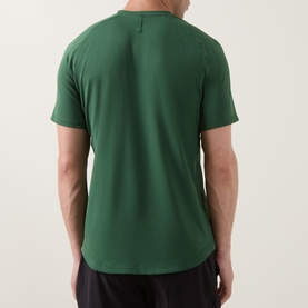 Model wearing Lululemon License to Train Short-Sleeve T-Shirt in Green Cove, rear view, paired with black shorts.