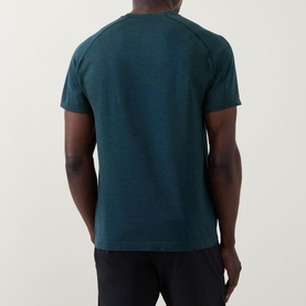 Model wearing Lululemon Metal Vent Tech Short-Sleeve T-Shirt in Green Cove/Club Blue, rear view, styled with black joggers.
