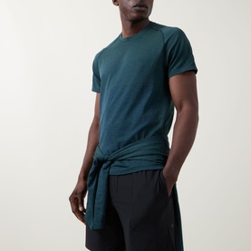 Model wearing Lululemon Metal Vent Tech Short-Sleeve T-Shirt in Green Cove/Club Blue, styled with black shorts, front knot detail visible.