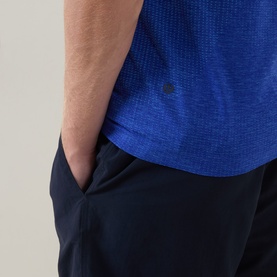 Model wearing Lululemon Metal Vent Tech Short-Sleeve T-Shirt in Ocean Wave/Beach Ball Blue, styled with navy shorts, hand in pocket.