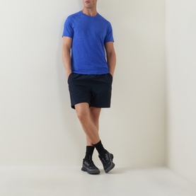 Model wearing Lululemon Metal Vent Tech Short-Sleeve T-Shirt in Ocean Wave/Beach Ball Blue, styled with navy shorts and black trainers.