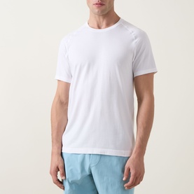 Model wearing Lululemon white performance T-shirt with crew neck and short sleeves, styled with light blue shorts.