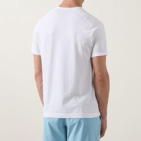 Model wearing Lululemon white performance T-shirt, rear view, styled with light blue shorts.