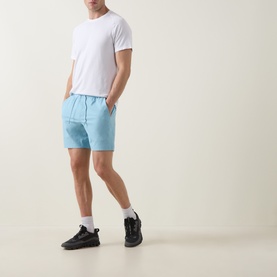 Model wearing Lululemon white T-shirt with light blue shorts, white socks and black trainers.