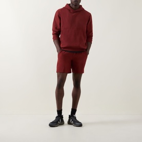 Model wearing Lululemon Cranberry Charm shorts, styled with a matching hoodie and black chunky trainers.