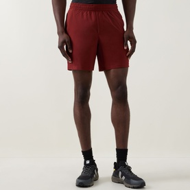 Model wearing Lululemon Cranberry Charm performance shorts, styled with dark trail trainers
