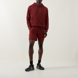 Model wearing Lululemon Cranberry Charm shorts with matching hoodie and black trainers.