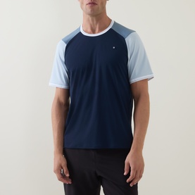 Model wearing Lululemon UV-Protective Textured Mesh Tennis Shirt in Club Blue/Steel Blue/Starch Blue colourblock, styled with black shorts.