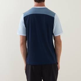 Model wearing Lululemon UV-Protective Textured Mesh Tennis Shirt in Club Blue/Steel Blue/Starch Blue, rear view, styled with dark shorts.