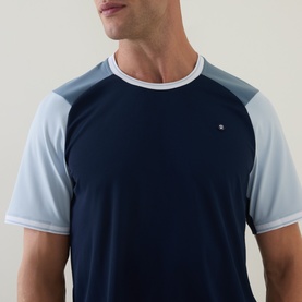 Model wearing Lululemon UV-Protective Textured Mesh Tennis Shirt in Club Blue with Steel Blue and Starch Blue contrast raglan sleeves