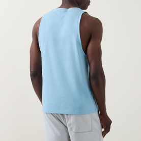 Model wearing Lululemon seafoam sleeveless performance T-shirt, back view, styled with light grey shorts.