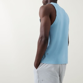Model wearing Lululemon seafoam sleeveless performance tank top, back view, styled with light grey shorts.