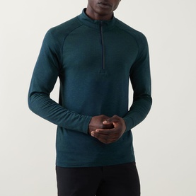 Model wearing Lululemon Metal Vent Short Sleeve T-Shirt in Green Cove/Club Blue, shown as long-sleeve half-zip top, styled with black trousers