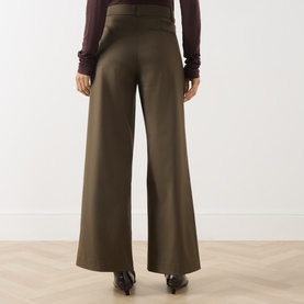 Model wearing Vivere Olive Green wide-leg trousers, rear view, styled with a burgundy top and black heeled boots.