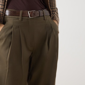 Model wearing Vivere Olive Green trousers with pleated front detail, styled with a brown leather belt and check top.