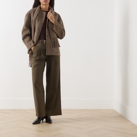 Model wearing Vivere Olive Green wide-leg trousers, styled with a brown houndstooth jacket and black heeled boots.