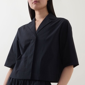 Model wearing Marc O Polo Woven Cropped Blouse in black with notch lapel collar, half-length sleeves and concealed front fastening
