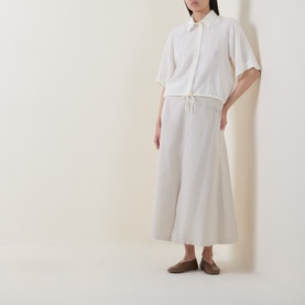Model wearing Marc O Polo Textured Drawstring Blouse in white, with kent collar, half sleeves and drawstring hem, styled with a cream midi skirt and