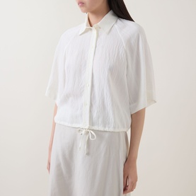 Model wearing Marc O Polo Textured Drawstring Blouse in white, showing kent collar, half-length sleeves, front buttons and drawstring hem.