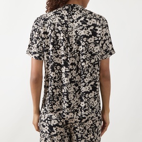 Model wearing Marc O Polo Floral Fluid Blouse in black multi, short sleeves, dropped shoulders, floral print, rear view, styled with matching