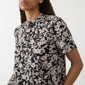 Model wearing Marc O Polo Floral Fluid Blouse in black multi, short sleeves, standing collar, all-over floral print, soft twill fabric
