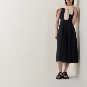 Model wearing Marc O Polo Woven Flared Dress in black, midi length with flared skirt, styled with a blush scarf and black sandals.