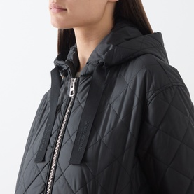 Model wearing Marc O Polo black quilted hooded coat with silver zip fastening and branded tape detail, close-up shot.