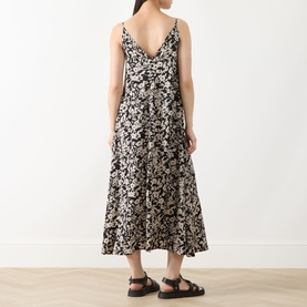 Model wearing Marc O Polo black multi floral print midi dress with thin straps, flared skirt, styled with black flat sandals, rear view.