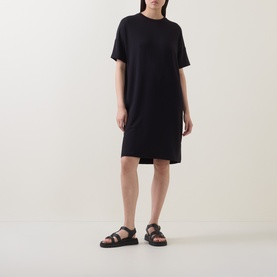 Model wearing Marc O Polo Solid Sweatshirt Dress in black, short sleeves, round neck, mini length, styled with black flatform sandals.