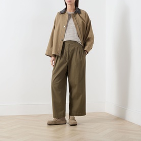 Model wearing Marc O Polo Linen Beige knitwear, styled with an olive wide-leg trousers, beige jacket and loafers.