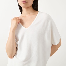 Model wearing Marc O Polo white cotton knit top with V-neckline and relaxed short sleeves, close-up detail view