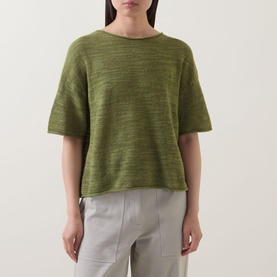Model wearing Marc O Polo Shaded Fern linen-cotton knit top with short sleeves and boat neck, styled with light grey trousers.