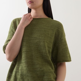Model wearing Marc O Polo Shaded Fern linen-cotton knit top with short sleeves and relaxed fit, hand resting at neckline.