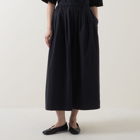 Model wearing Marc O Polo black gathered midi skirt with elasticated waist, styled with black ballet flats and short-sleeve top.