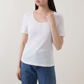Model wearing Marc O Polo Solid Slub T-Shirt in White Cotton with scoop neckline and short sleeves, styled with blue jeans