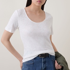Model wearing Marc O Polo Solid Slub T-Shirt in White Cotton with scoop neckline, styled with blue jeans and black belt.