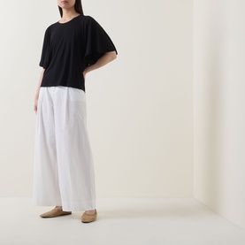 Model wearing Marc O Polo black short-sleeve relaxed T-shirt, styled with wide-leg white trousers and tan loafers.