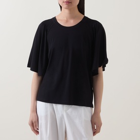 Model wearing Marc O Polo black T-shirt with flutter sleeves and round neckline, styled with white wide-leg trousers
