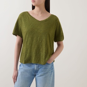 Model wearing Marc O Polo Wide Slub T-Shirt in Shaded Fern, V-neckline, dropped shoulders, styled with light blue jeans