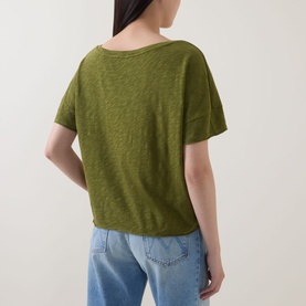 Model wearing Marc O Polo Wide Slub T-Shirt in Shaded Fern, back view showing dropped shoulders and straight hem, styled with light blue jeans.