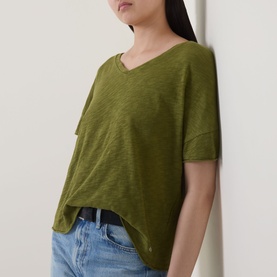 Model wearing Marc O Polo Wide Slub T-Shirt in Shaded Fern, V-neckline, dropped shoulders, styled with blue jeans