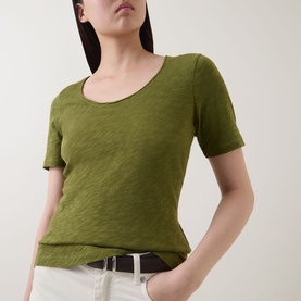 Model wearing Marc O Polo Solid Slub T-Shirt in Shaded Fern, scoop neckline, short sleeves, styled with white jeans and belt.