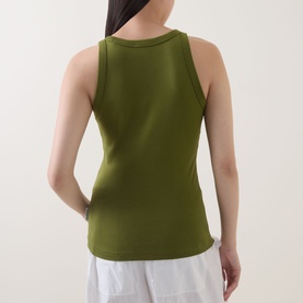 Model wearing Marc O Polo Solid Logo Tank Top in Shaded Fern, rear view, wide straps, round neck, with white trousers