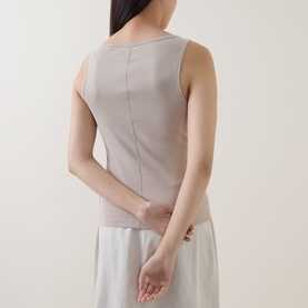 Model wearing Marc O Polo Linen Beige sleeveless cotton T-shirt, back view, styled with white wide-leg trousers