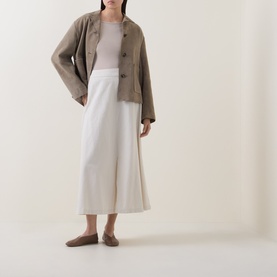 Model wearing Marc O Polo Linen Beige cotton T-shirt, styled with khaki jacket, white wide-leg trousers and flat shoes.
