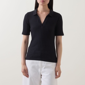 Model wearing Marc O Polo Pointelle Polo Sweater in black, ribbed knit with V-neck polo collar and short sleeves, styled with white trousers