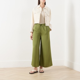 Model wearing Marc O Polo Shaded Fern wide-leg trousers in viscose, styled with a cream cropped jacket and white sandals.