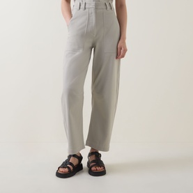 Model wearing Marc O Polo Linen Beige trousers with wide-leg fit and patch pockets, styled with black chunky sandals.